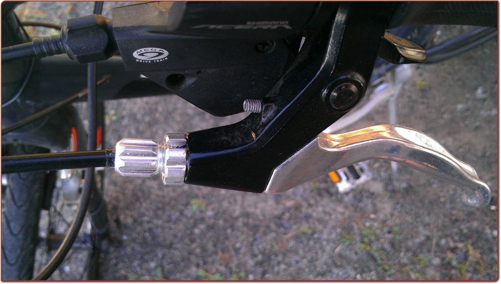 Close-up of the lock nut being screwed back into place to secure the brake adjustment