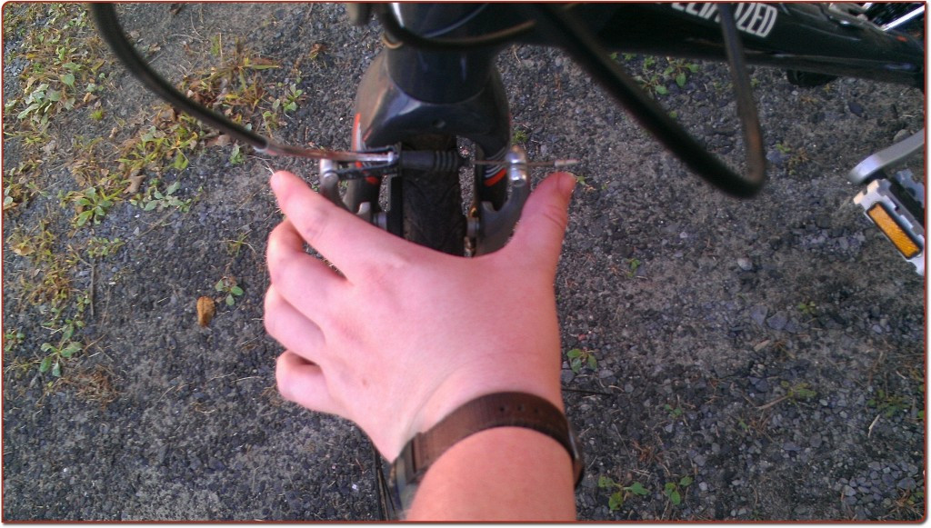 Hands grasping the brake calipers, ready to squeeze them closed