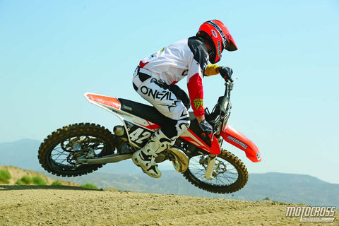 A 2016 125cc two-stroke dirt bike in action, highlighting its engine and power.