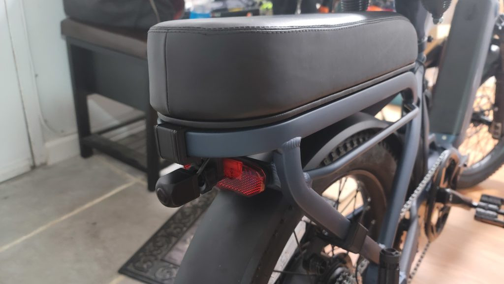 Close up of foldable foot pegs mechanism on a two person electric bike
