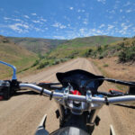 Rider on a Yamaha XT250 dual sport bike on a dirt trail, showcasing its off-road capability.