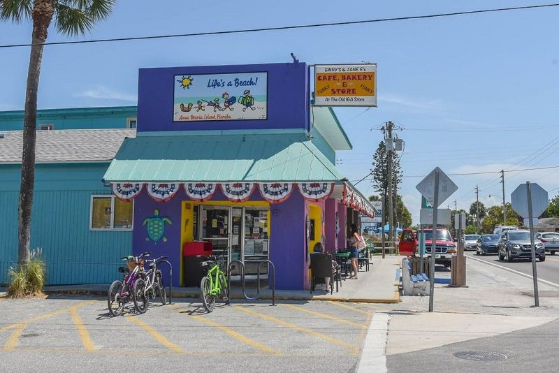 Couple riding tandem bicycle on a paved path near the beach, rented from Anna Maria Island Adventure Rentals