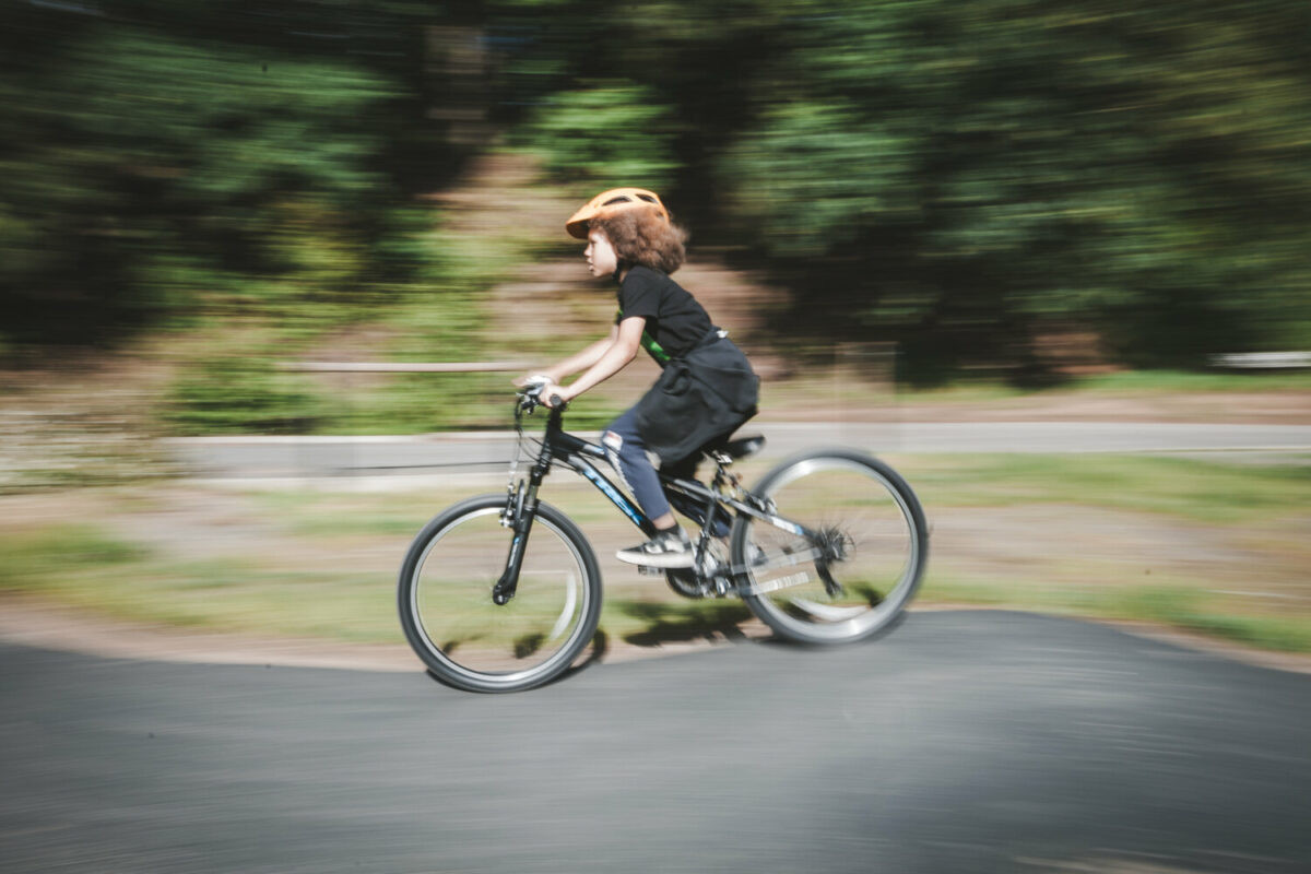 Boys mountain biking downhill towards the trails
