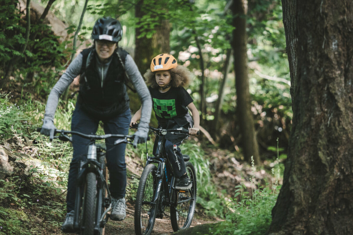 Close up of boys mountain biking on a trail