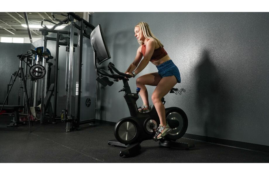 Product tester Caroline looking at the monitor on the Echelon EX-8 bike, evaluating its screen quality.