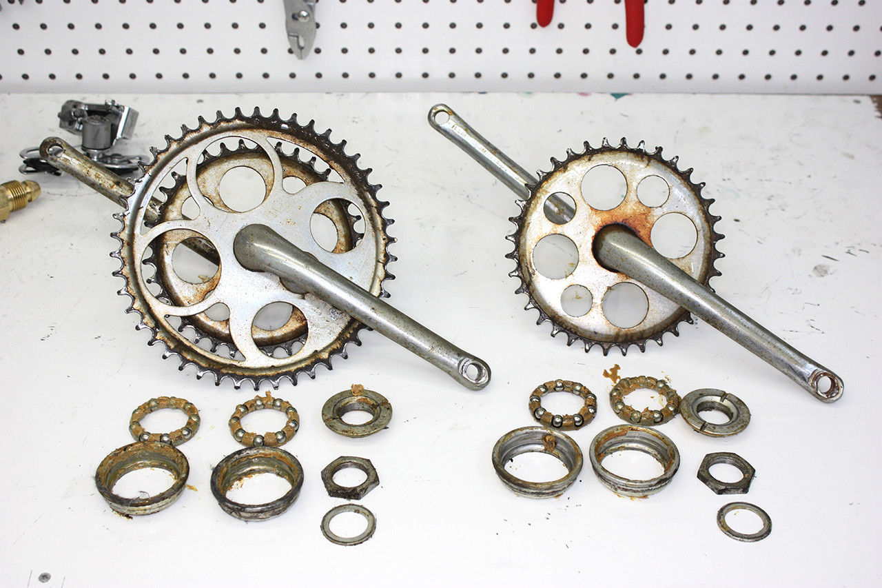 Crankset and components of the Schwinn Twinn Tandem before cleaning, showing grease and dirt accumulation.