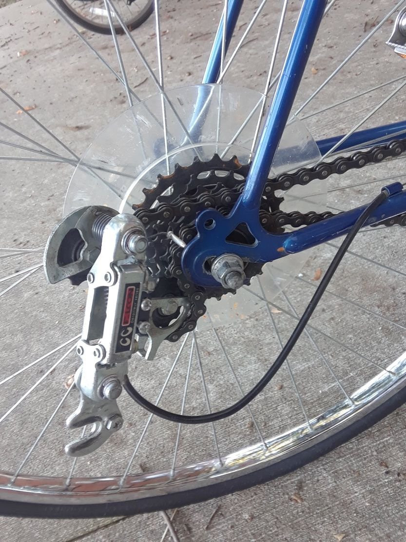 Close-up of a detached bicycle derailleur mechanism after an attempted wheel reinstallation