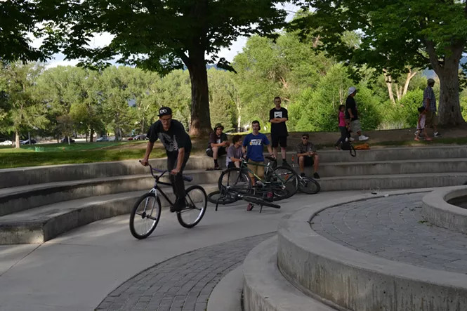 Fixed gear bike rider performing a trick, highlighting the dynamic and skillful nature of fixie bike freestyle riding in an urban environment.