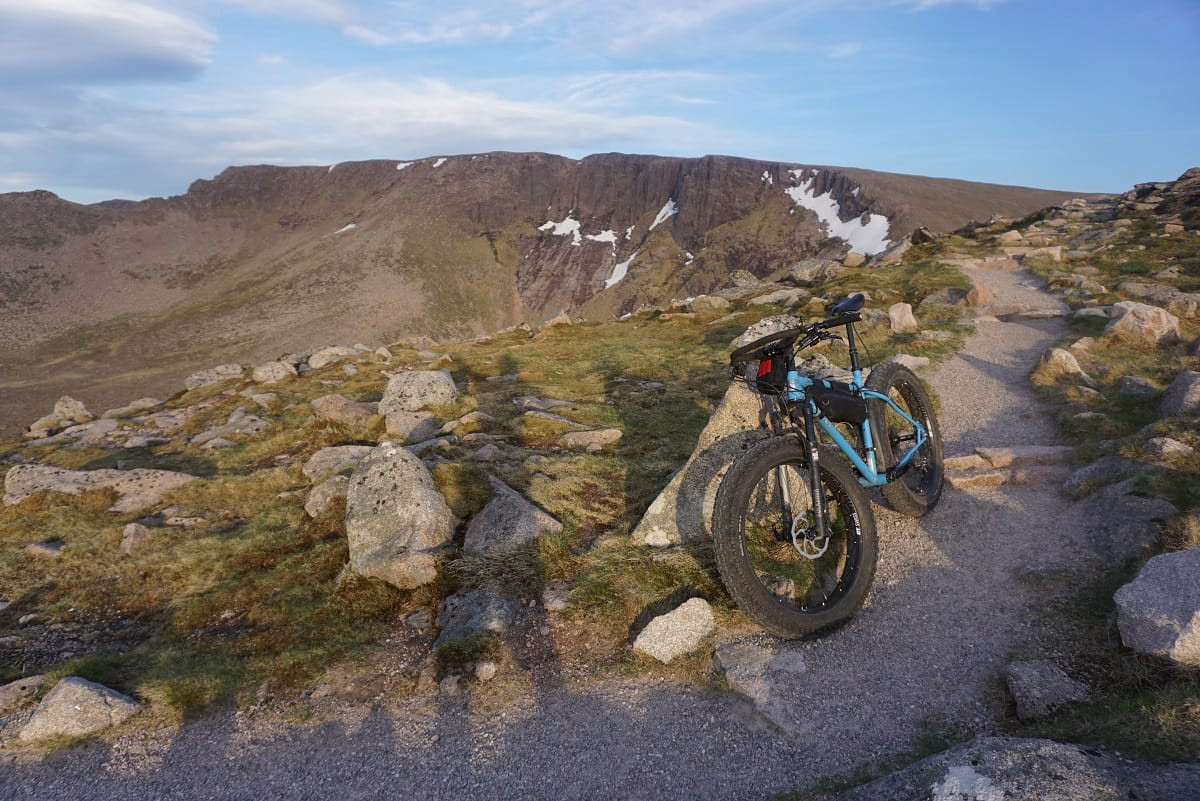 Rider on a fat bike with RockShox Bluto fork, nearing the end of a long 13-hour ride, emphasizing comfort and endurance