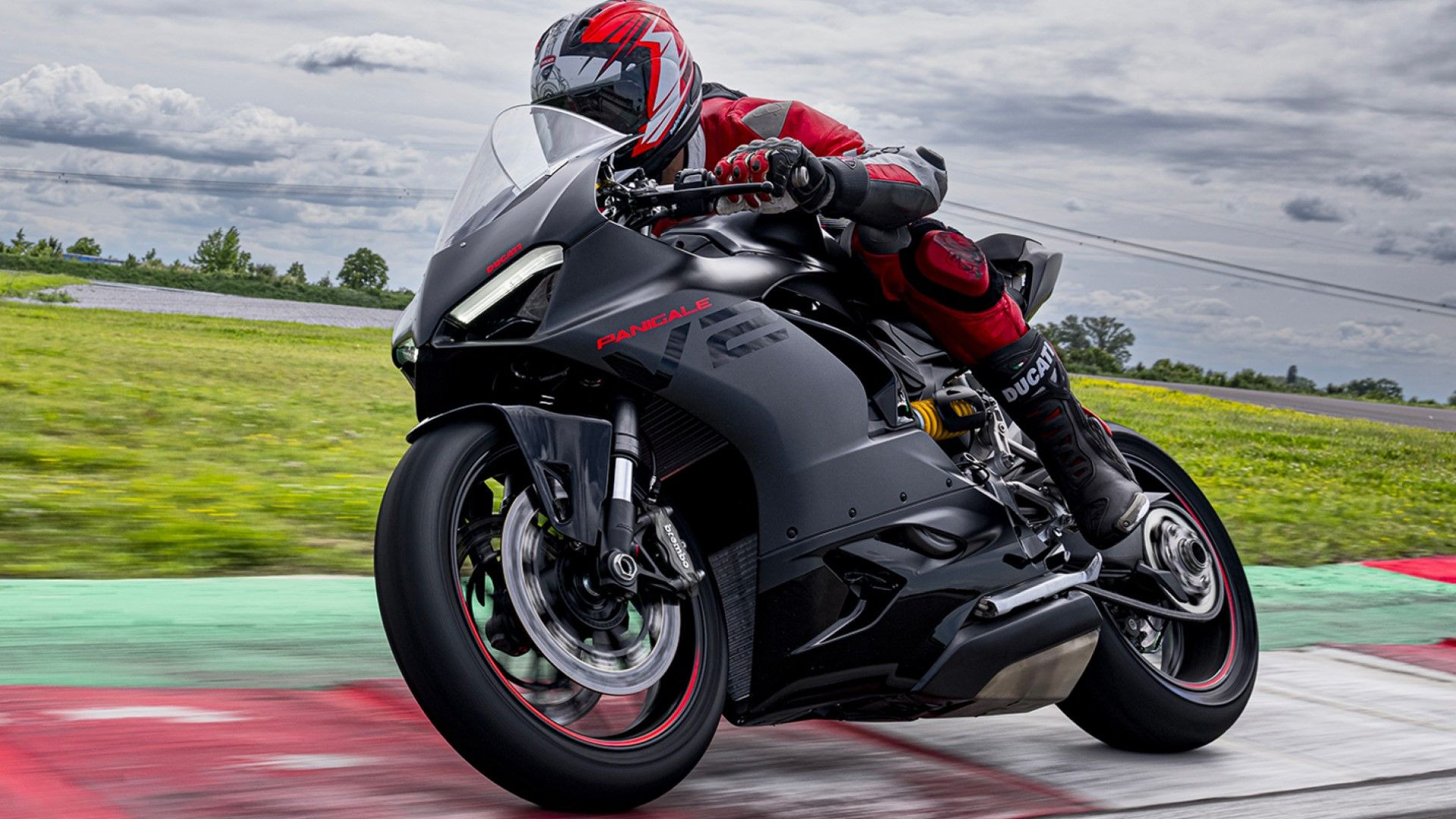 Ducati Panigale V2 in black cornering on a racetrack, emphasizing its aggressive lines and track-focused design