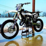 Red and white Husqvarna FC 125 dirt bike showcasing its features.