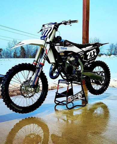 Red and white Husqvarna FC 125 dirt bike showcasing its features.