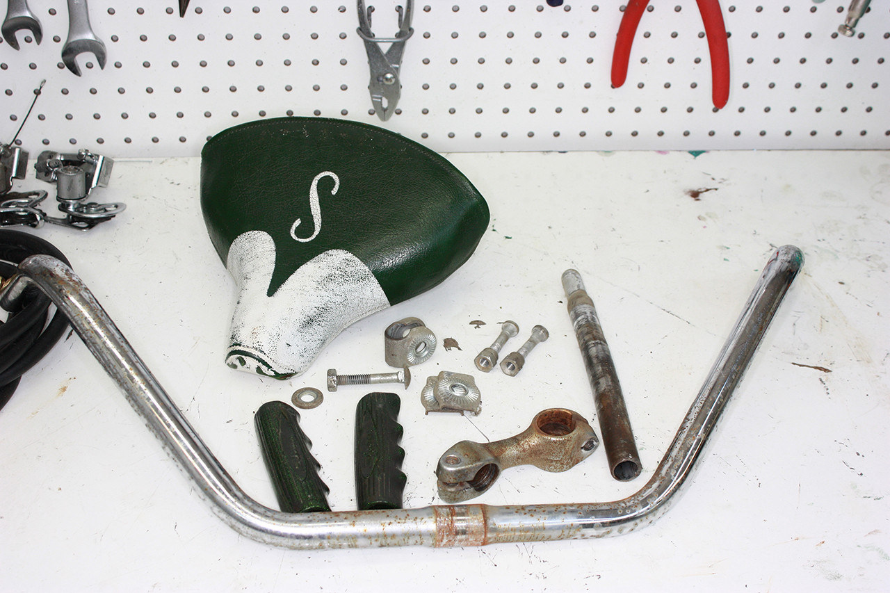 Disassembled front seat post and rear handlebars of the vintage Schwinn tandem, ready for cleaning and restoration.
