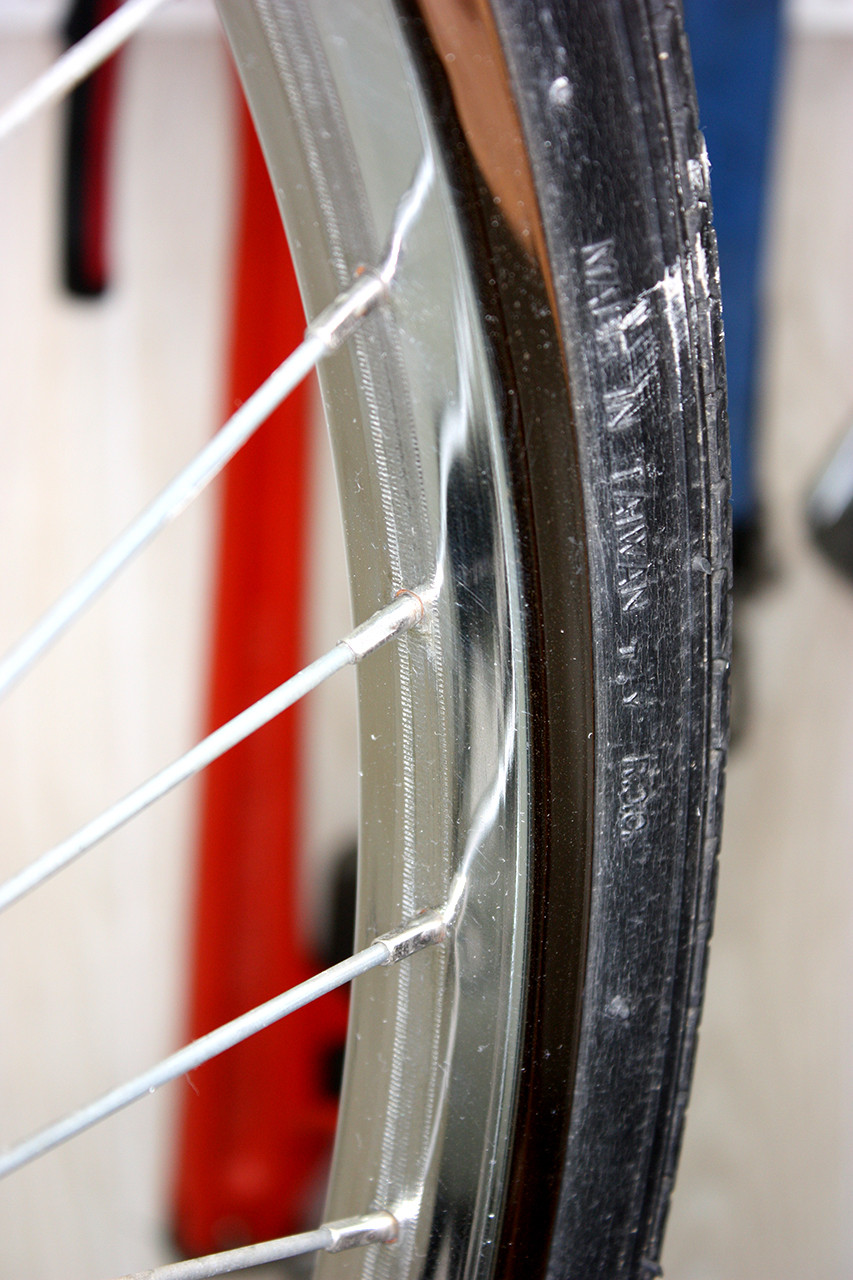 Front wheel rim of the vintage Schwinn tandem polished, demonstrating the successful removal of rust and corrosion.