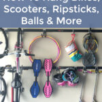 Garage with bikes, scooters, ripsticks, balls and more hung on the wall using a track system.