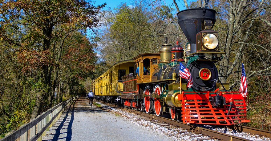 A vintage steam train adds historical charm to the Heritage Rail Trail County Park, enhancing the visitor experience.