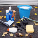 Bike washing supplies including bucket, soap, brushes, hose, and rags