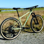 Rider on a Marin Pine Mountain 2 bike on a trail, showcasing its geometry and tire size.