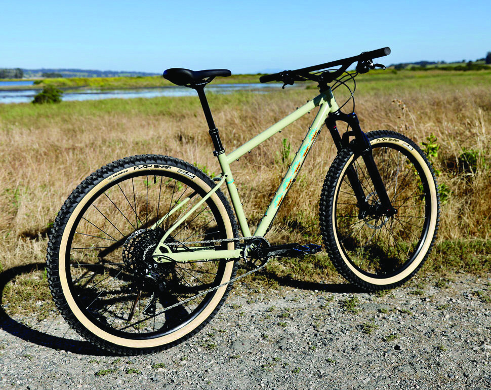 Rider on a Marin Pine Mountain 2 bike on a trail, showcasing its geometry and tire size.