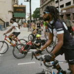 Diverse group of cyclists participate in the Black JoyRide Juneteenth community bike ride in Chicago, promoting unity and joy through crew bikes.
