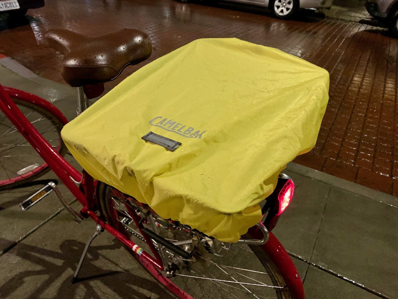A backpack cover on a bicycle basket to protect things from the rain. There
