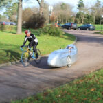 Silver recumbent bike speeding on a corner at Longchamp race track