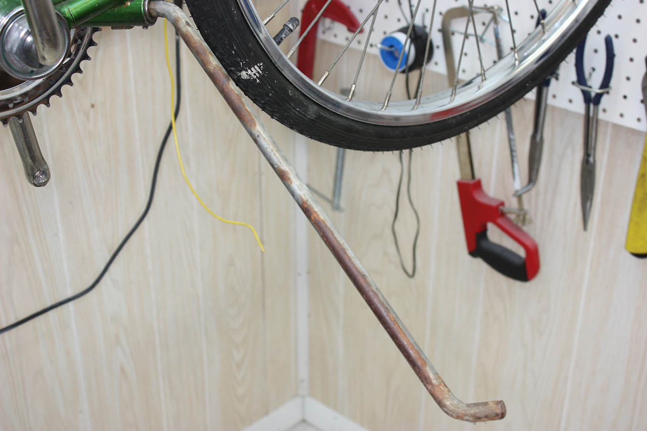 Kickstand of the Schwinn Twinn Tandem before cleaning, covered in rust and grime.