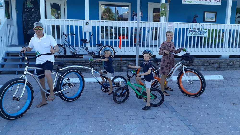 Exterior of Lazy Turtle Beach Rentals shop with various beach and bike rental items displayed