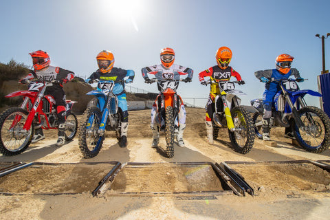 Motocross action shot of a 125cc two-stroke dirt bike in mid-air jump, showcasing the bike's agility and speed.