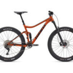 Giant Stance mountain bike in Amber Glow color, showcasing its full suspension trail bike design