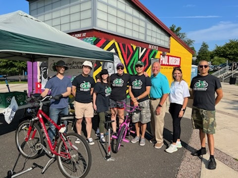 Mayor James Cahill visiting the New Brunswick Bike Exchange Bike Rodeo event with NBBX volunteers ensuring bicycle safety checks and community engagement.
