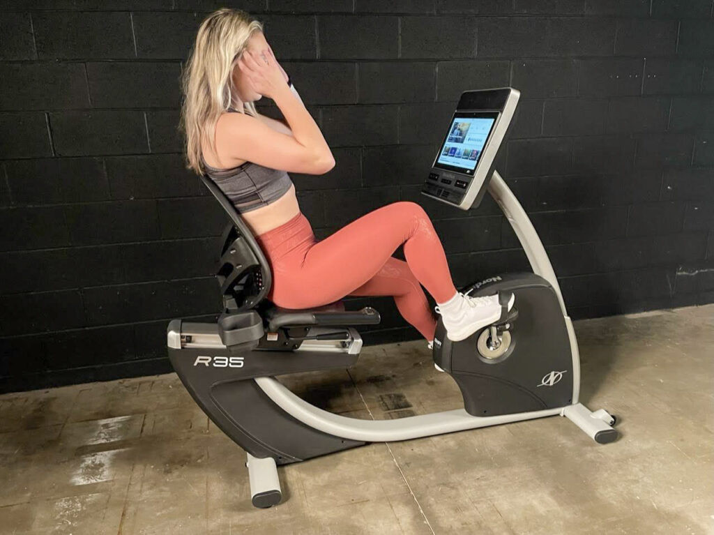 Product tester Caroline Lubinsky using the NordicTrack Commercial R35 recumbent bike, highlighting its comfort and screen.