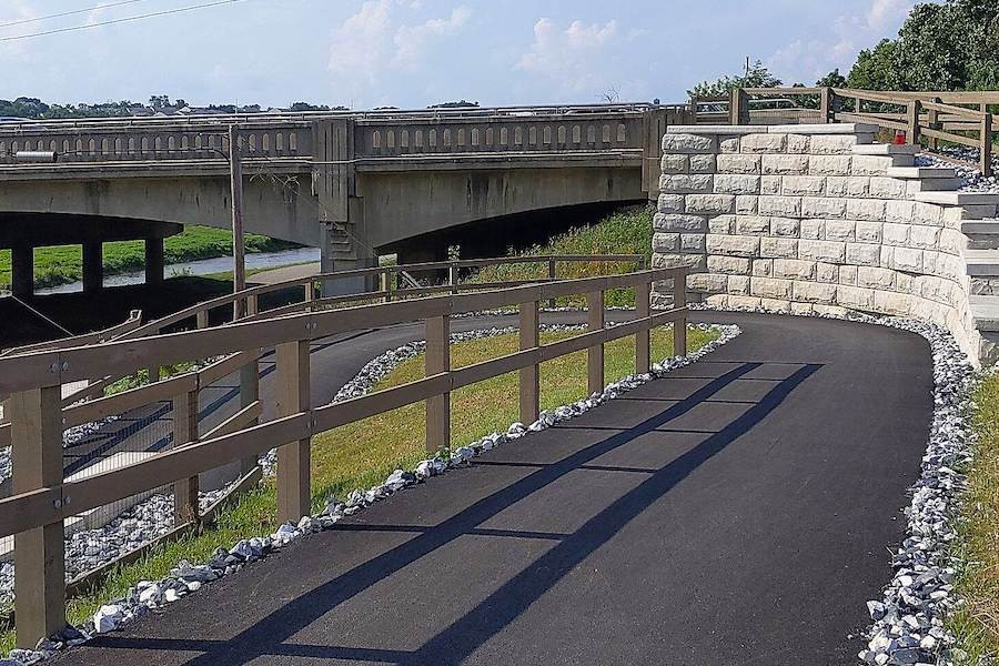 Cyclists ride through a historic section of the Heritage Rail Trail County Park in Pennsylvania, with vintage railroad elements.
