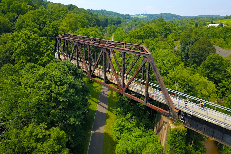 A cyclist enjoys the Montour Trail in Pennsylvania, riding through a tunnel surrounded by natural landscapes.