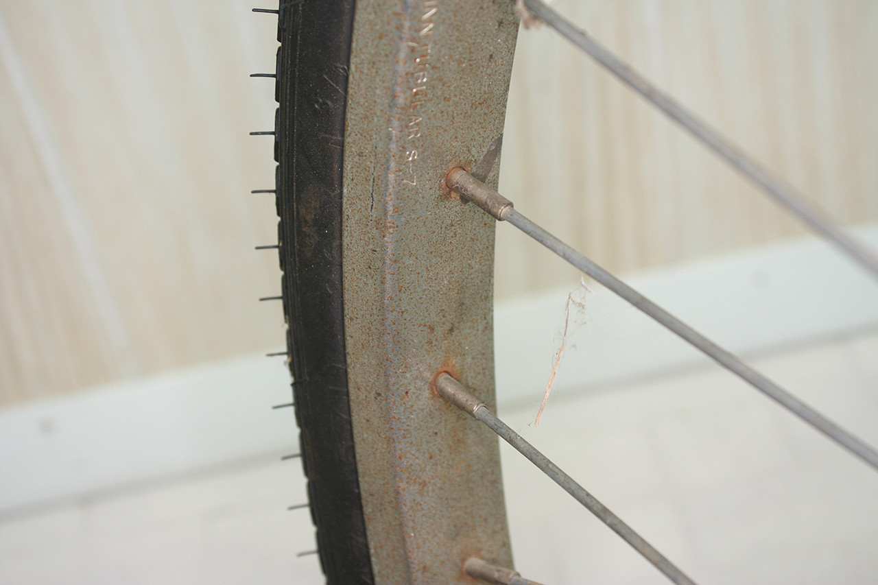 Detailed shot of the Schwinn S-7 stamp on the rear wheel rim of the Steve Schwinn Twinn Tandem, before cleaning.