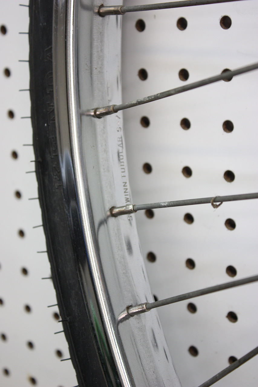 Rear wheel rim of the Schwinn Twinn Tandem after initial cleaning and polishing, revealing improved condition.