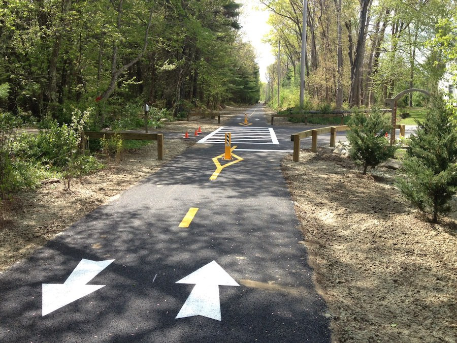 The Burrillville Bike Path in Rhode Island, a paved trail through a rural wooded setting