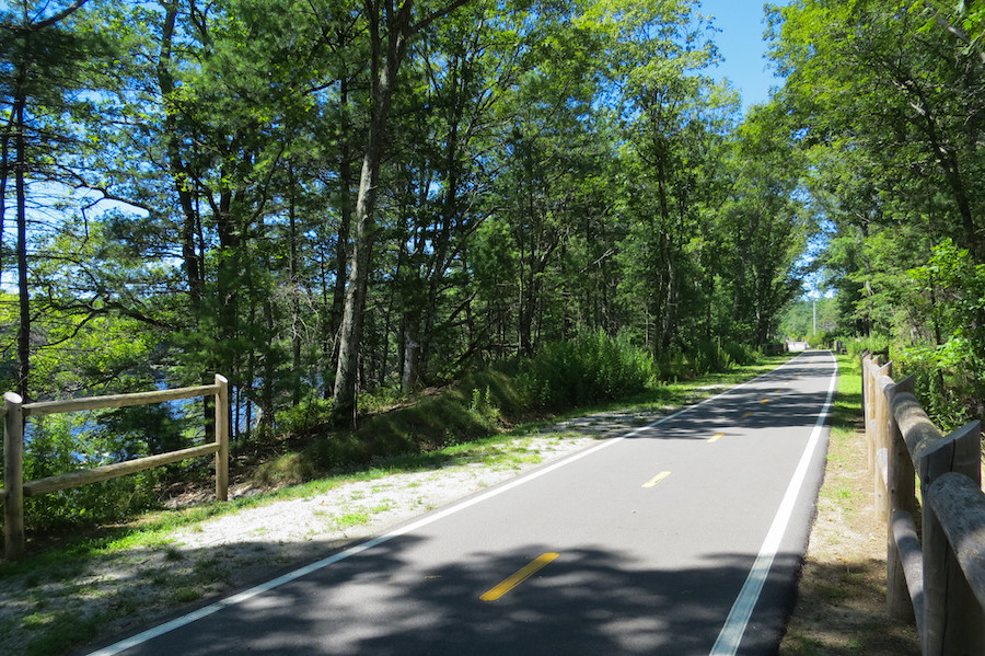 The Washington Secondary Bike Path in Rhode Island, featuring a paved trail through a wooded area with autumn foliage