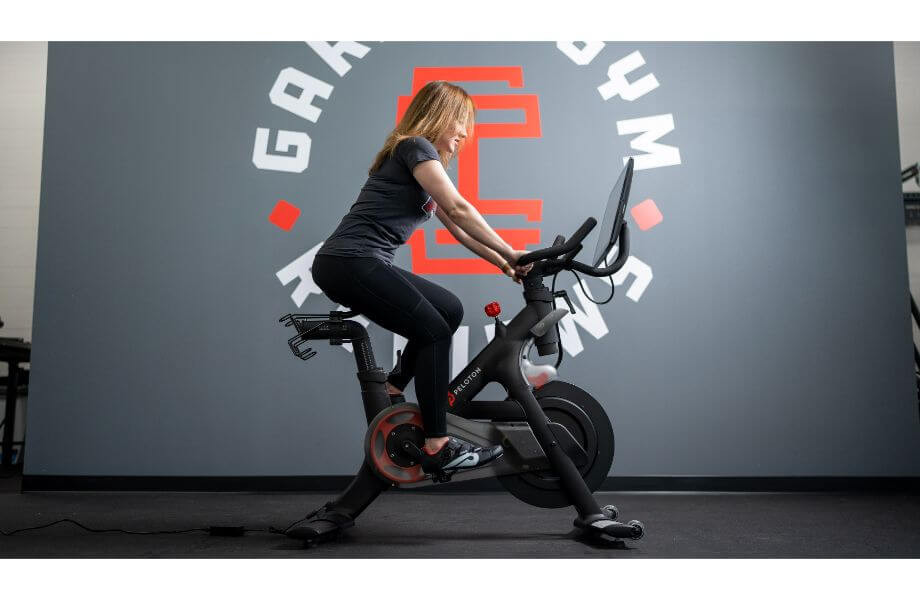 Person enthusiastically using a Peloton Bike+, highlighting the engaging workout experience.