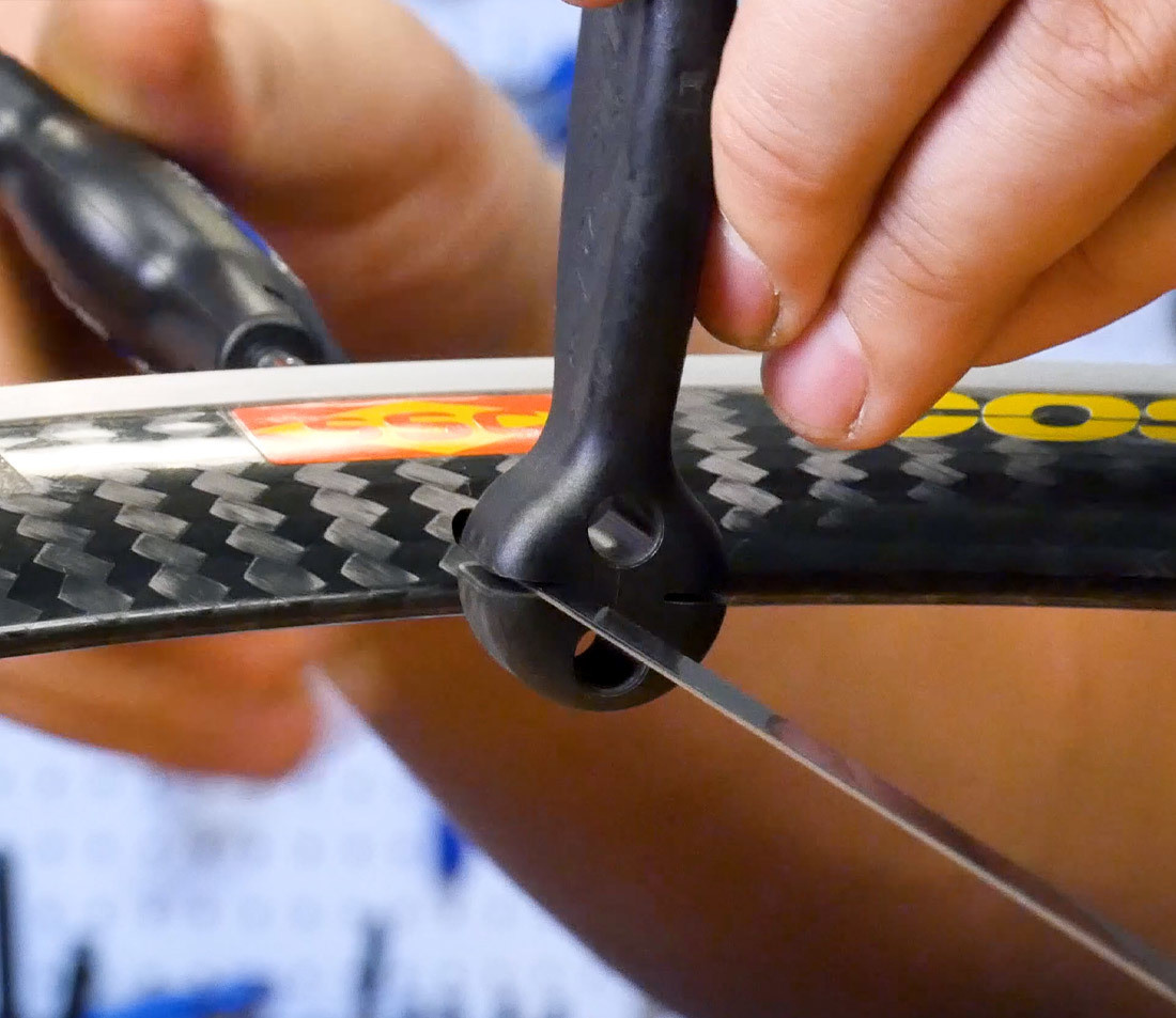 Bladed bicycle spoke being held in place by a bladed spoke holder