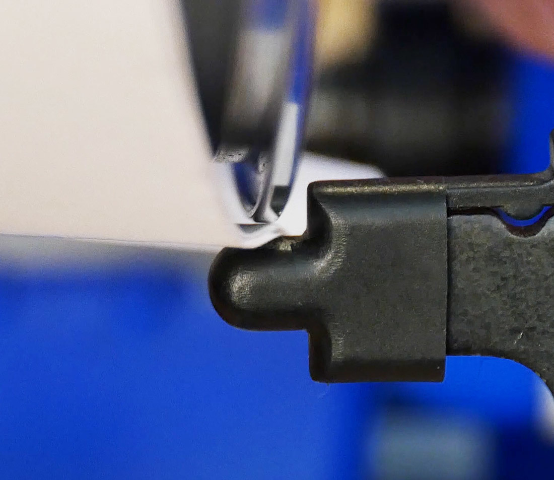 Bottom edge of rim and truing stand indicator underneath with 10 pieces of paper in between