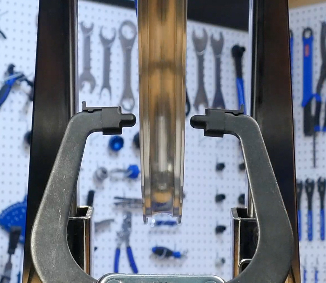 Head-on view of bicycle wheel in truing stand, demonstrating better visibility of indicators with tire removed