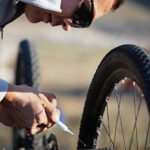 A bicycle mechanic lubricating a chain