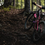 Mountain biker checking spokes on wheel after noticing damage