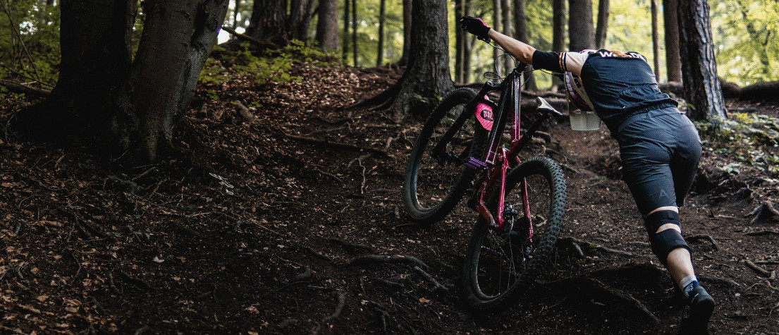 Mountain biker checking spokes on wheel after noticing damage