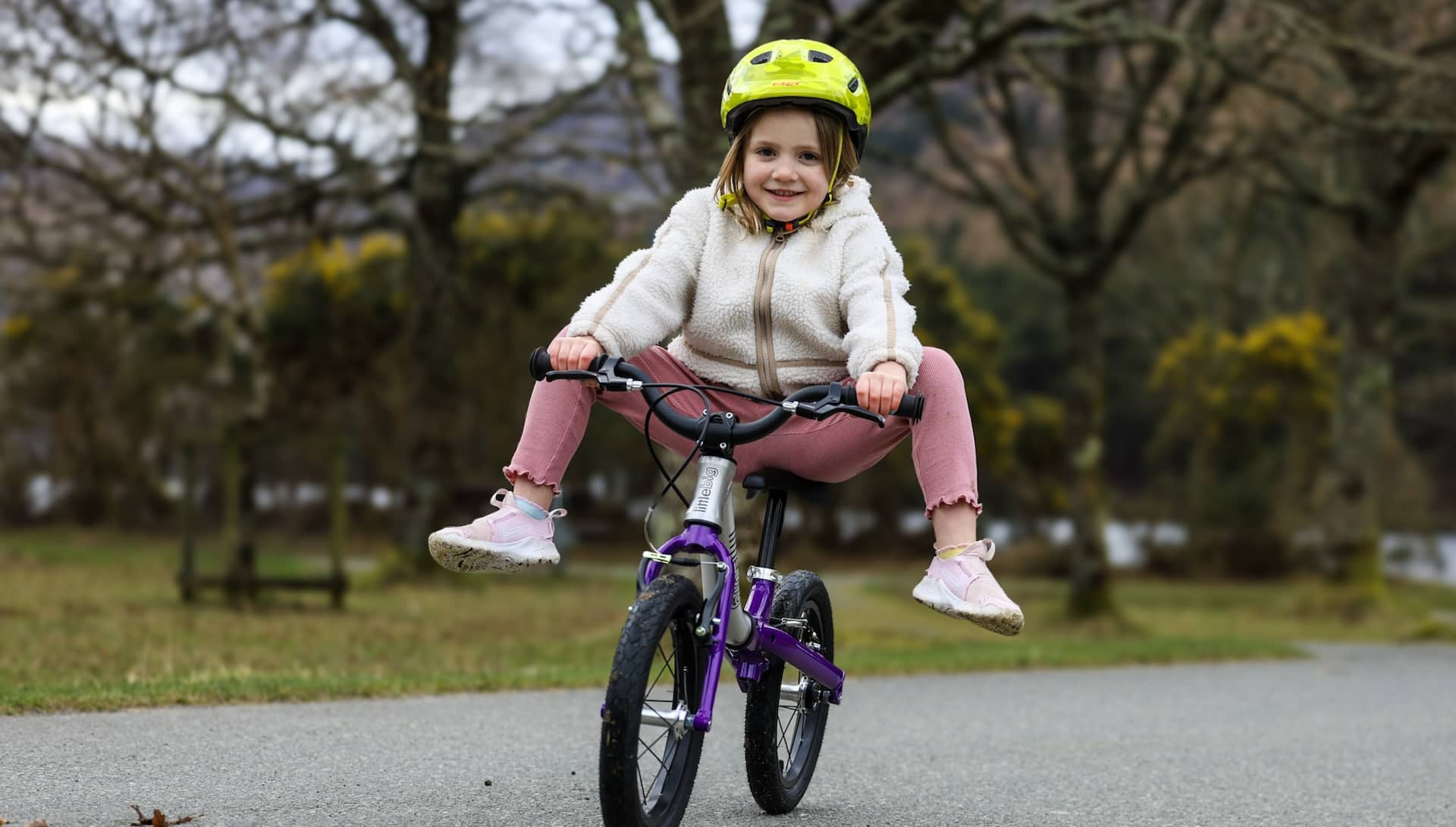 Girl lifting her feet while gliding on a LittleBig balance bike