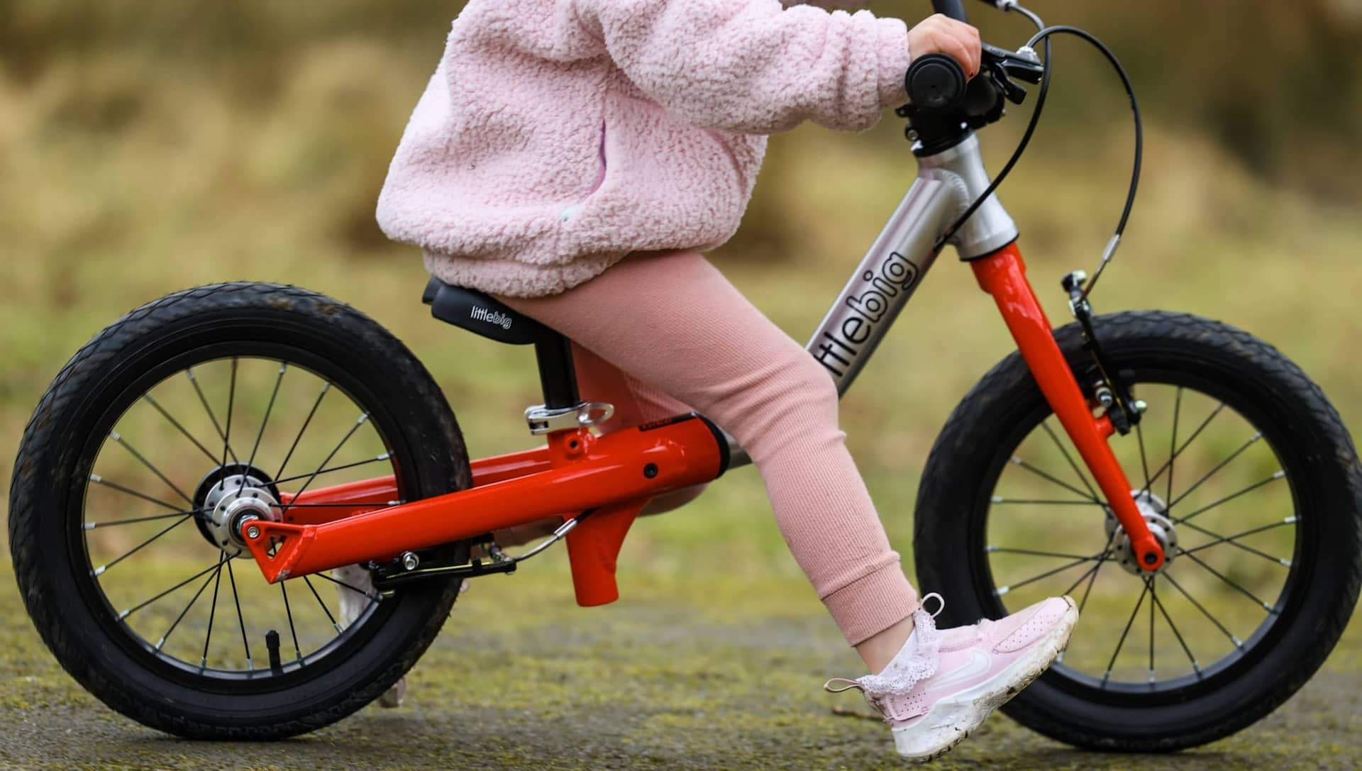 Girl riding LittleBig balance bike with brakes