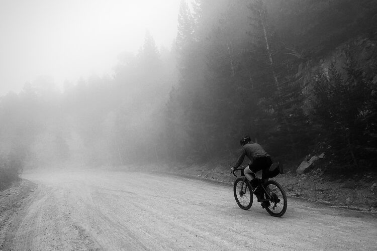 Mountain biker riding through forest trails, showcasing the bike's suspension and rugged tires