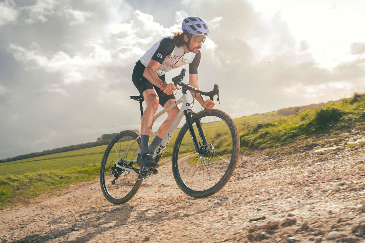 Gravel cyclist riding GT Grade Carbon X on mixed terrain