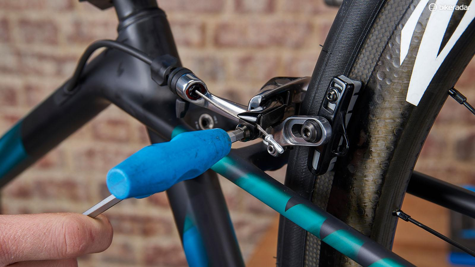 Tightening the brake cable to move the pads closer to the rims for optimal braking.